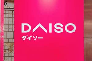 ダイソーのロゴが大きく表示されたピンクの看板