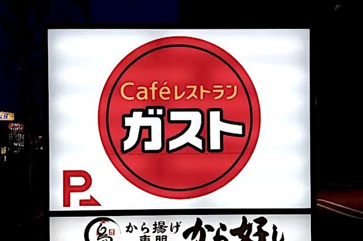 Illuminated sign for ‘Café’ with parking available, in Japanese, with additional text and symbols below