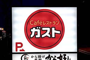 Illuminated sign for 'Café' with parking available, in Japanese, with additional text and symbols below