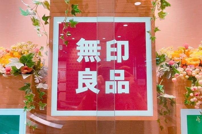 窓ガラスに「無料案内」と書かれたサイン、周囲は花で飾られています。