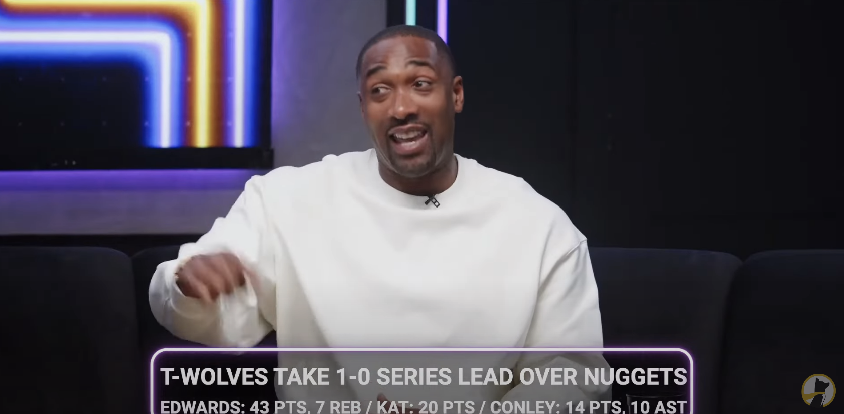 Gilbert Arenas, in a white top, gestures while discussing basketball highlights on TV show. Text overlay with game scores