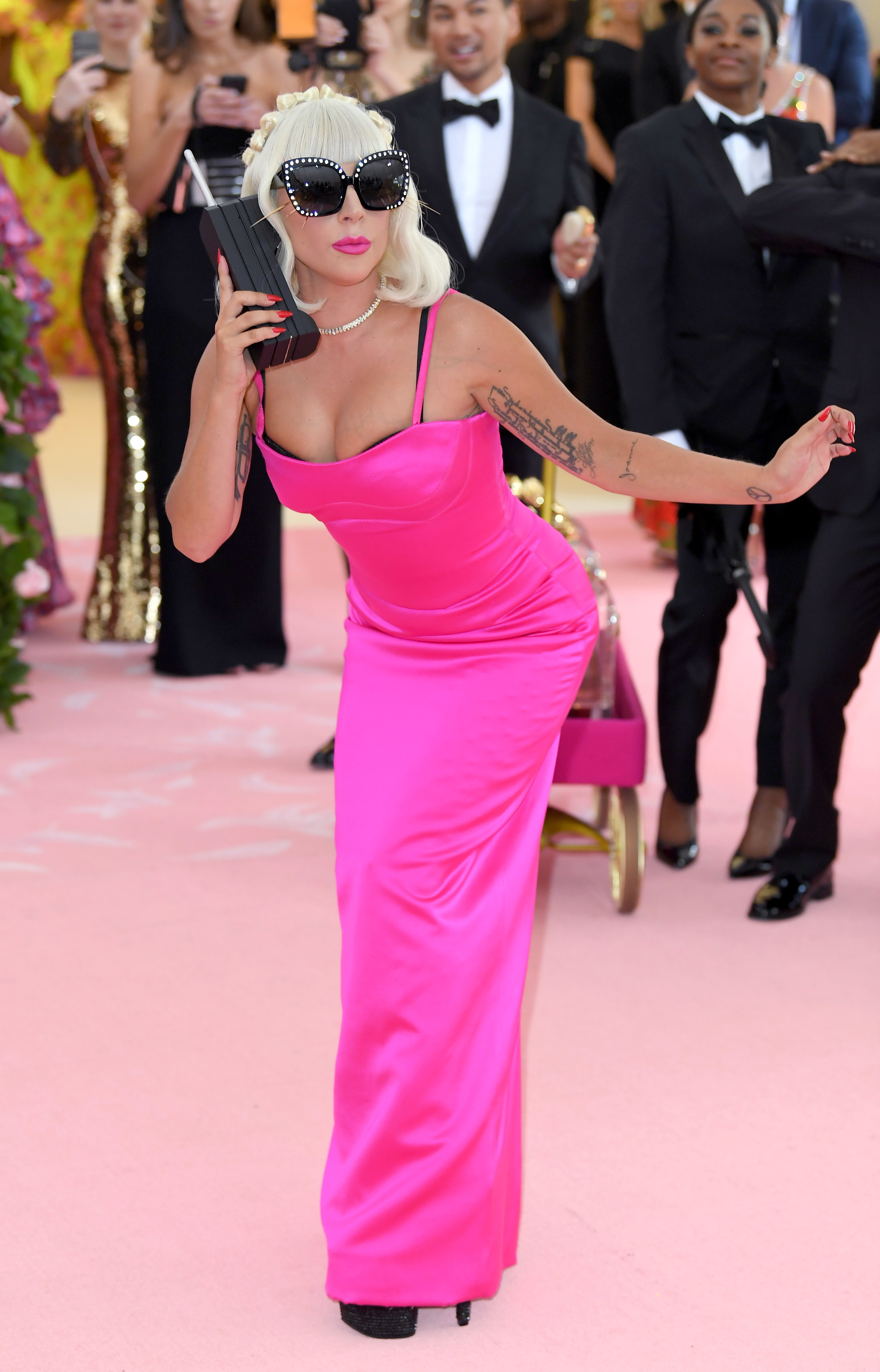 Lady Gaga in a column gown with a large phone prop,