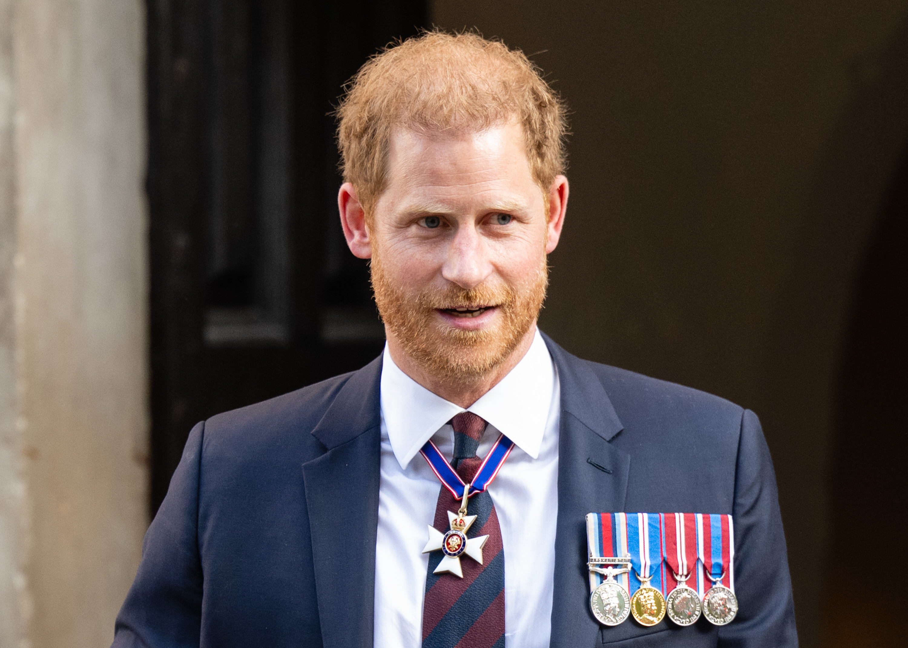 Prince Harry in a dark suit with medals, attending a formal event