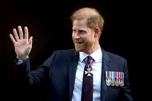 Prince Harry in suit with medals waving