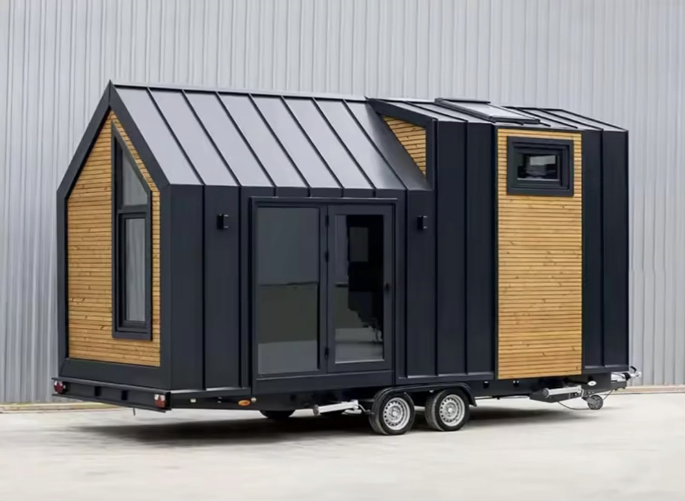 Modern tiny house on wheels with sliding door and wood paneling, featured in a Nifty article