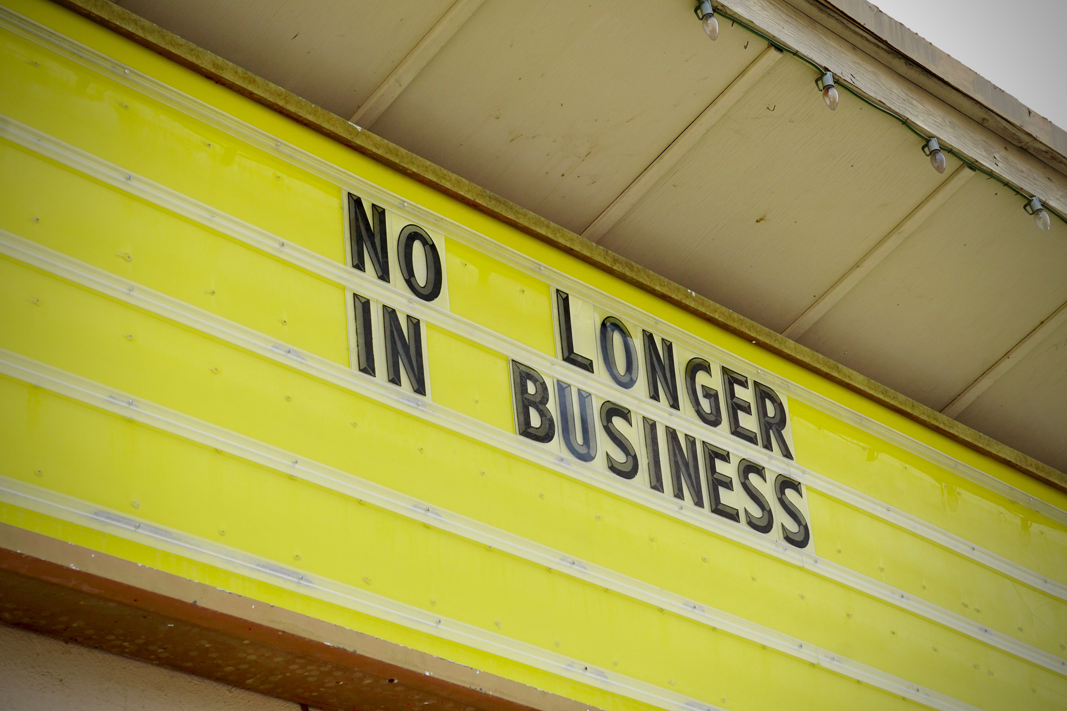 Sign on building reads &quot;NO LONGER IN BUSINESS,&quot; indicating a closed establishment