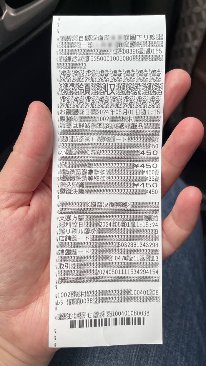 手に持たれたレシートの画像。日付や金額、商品名など購入明細が印刷されている。