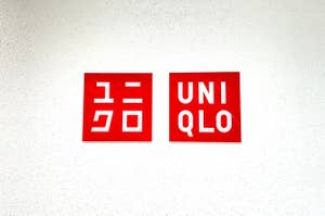 Two logos on a wall, one in Japanese characters and another reads "UNIQLO."