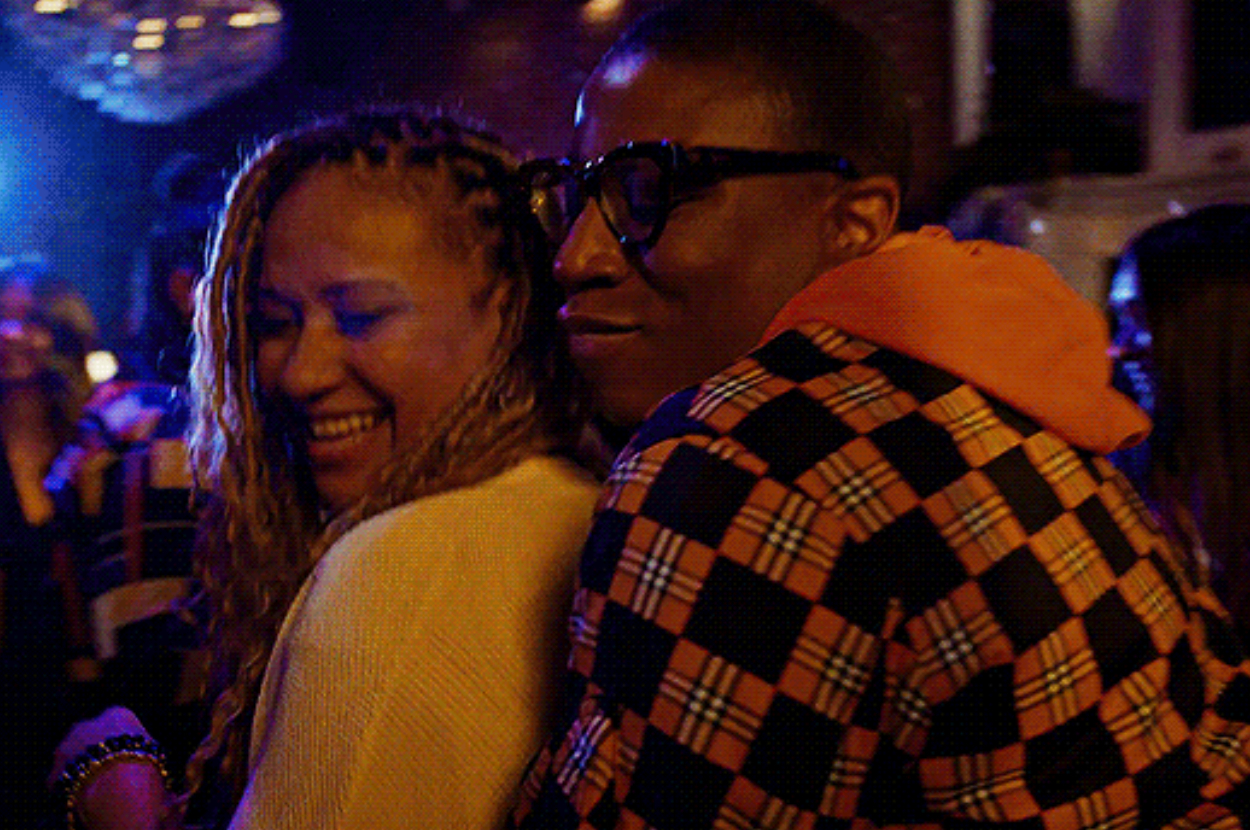 Two people smiling and embracing at a social event