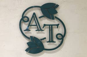 壁に取り付けられた装飾的な「AT」のロゴ。