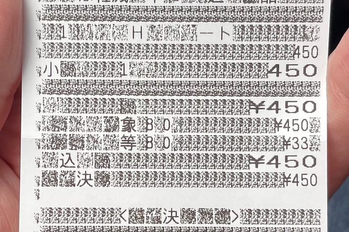 手に持たれたレシートの画像。日付や金額、商品名など購入明細が印刷されている。