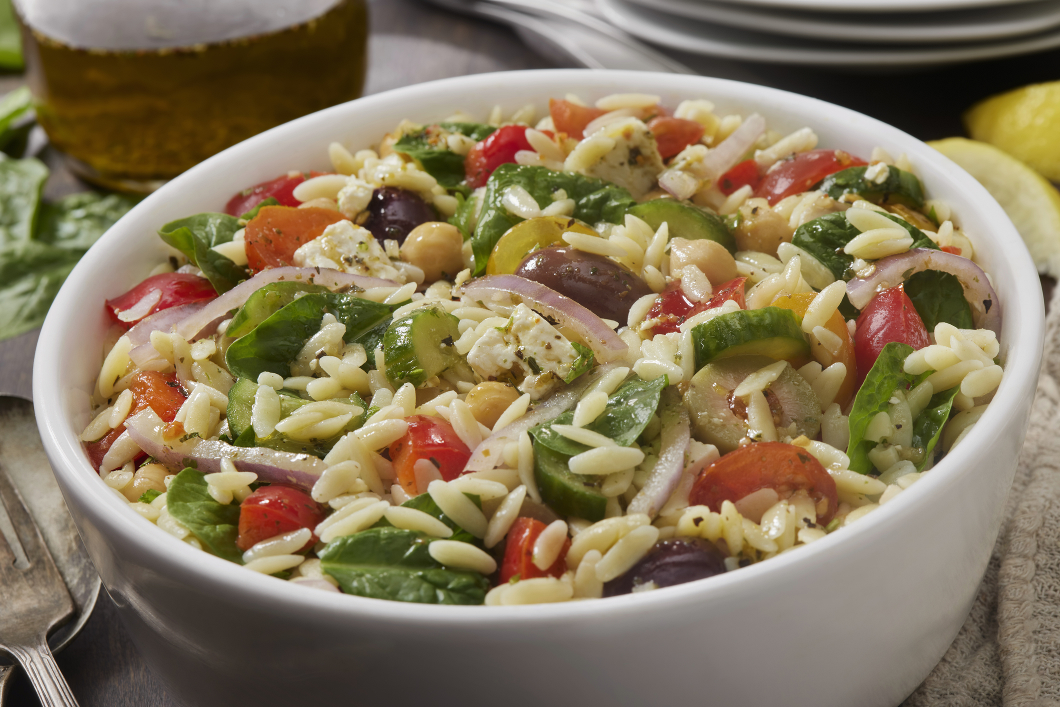 Bowl of pasta salad with vegetables and chickpeas on a table
