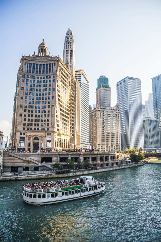 Chicago river with a tour boat and surrounding skyscrapers