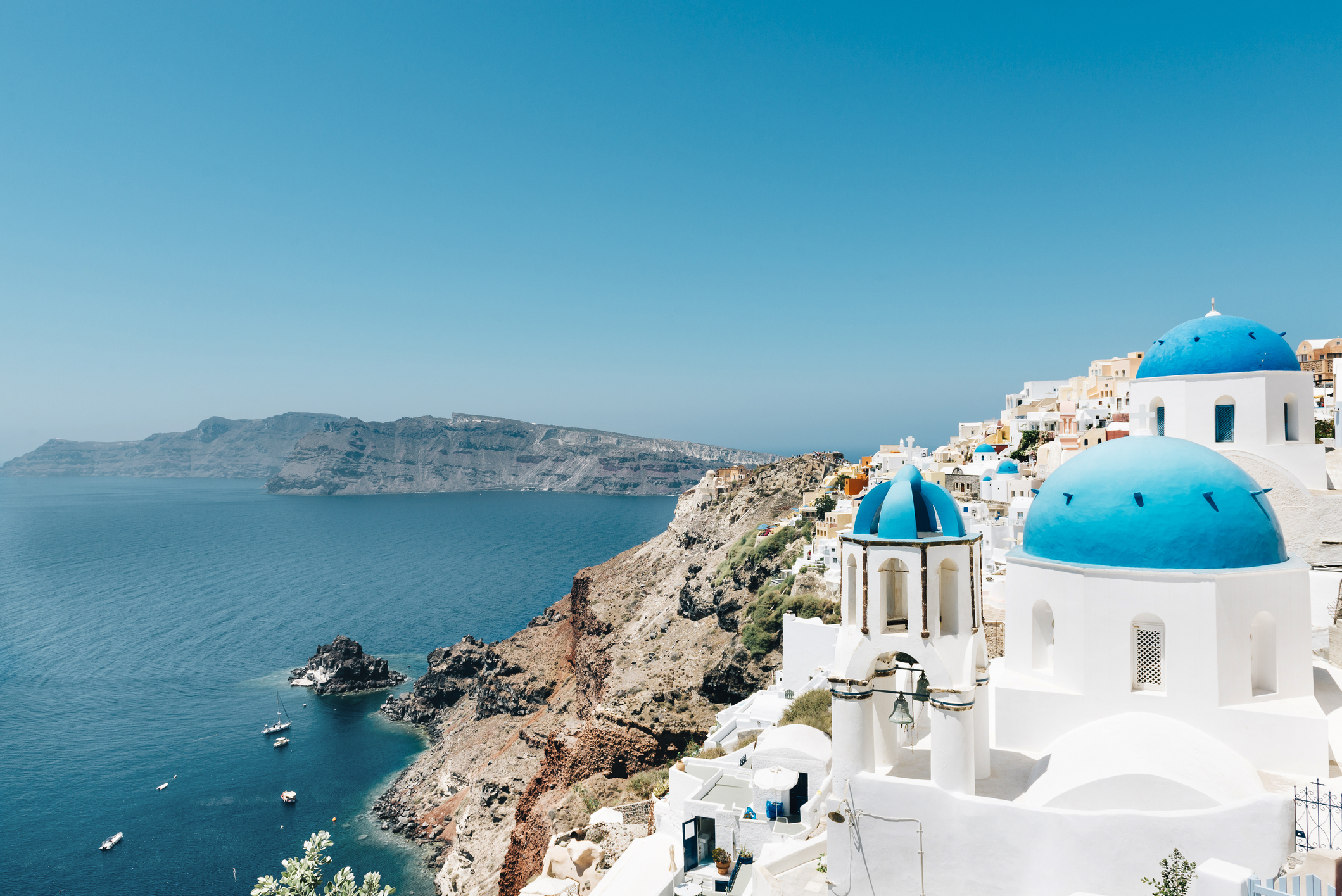 Scenic view of Santorini with iconic blue-domed churches and buildings overlooking the sea