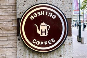 星野コーヒーの看板。ティーポットのロゴが特徴。街中の壁に取り付けられている。