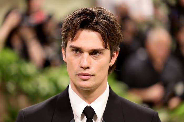 Nicholas Galitzine in a classic suit and tie with styled hair, at a formal event