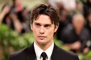 Nicholas Galitzine in a classic suit and tie with styled hair, at a formal event