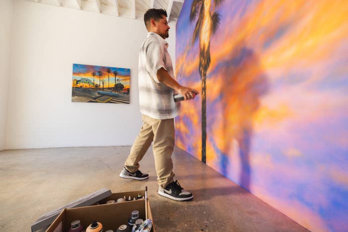 Artist in casual wear paints a mural, focus on detailed sneakers