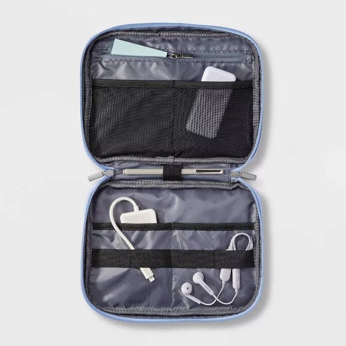 Open tech accessory organizer with pockets holding cables and earphones