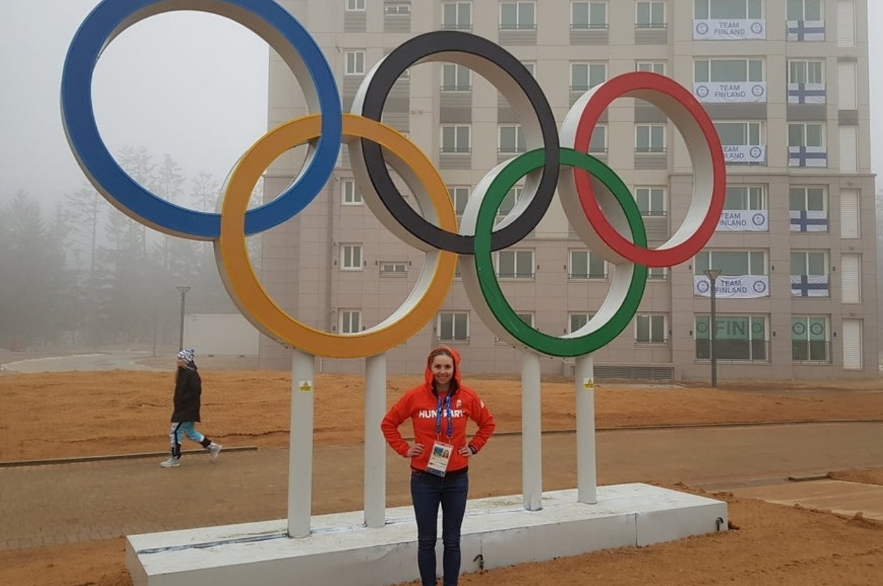 Person standing in front of Olympic Rings at a foggy Olympic Village