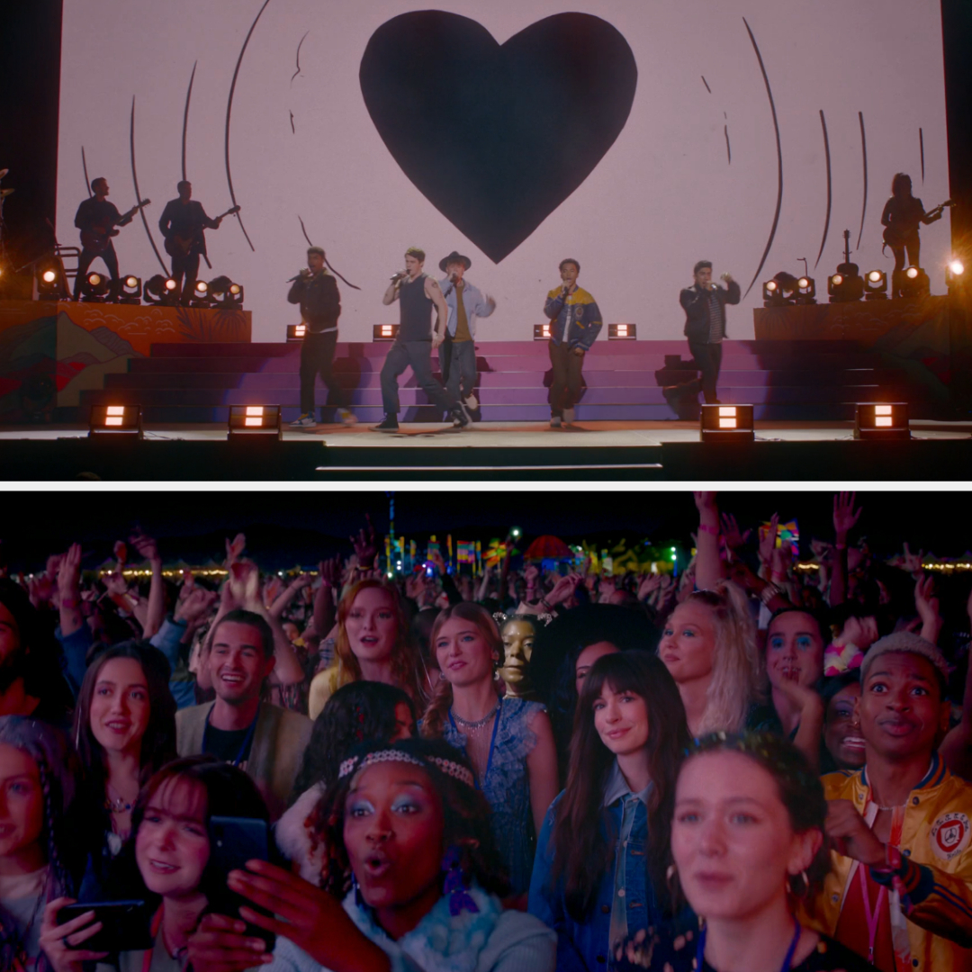 Group of performers on stage with heart backdrop above crowd enjoying the show