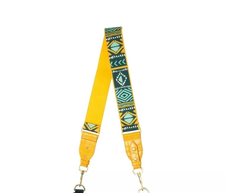 Tribal-patterned yellow and teal bag strap attached to a green bag