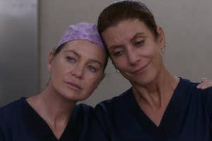 Two women in medical scrubs, one with a surgical cap, appear concerned or supportive
