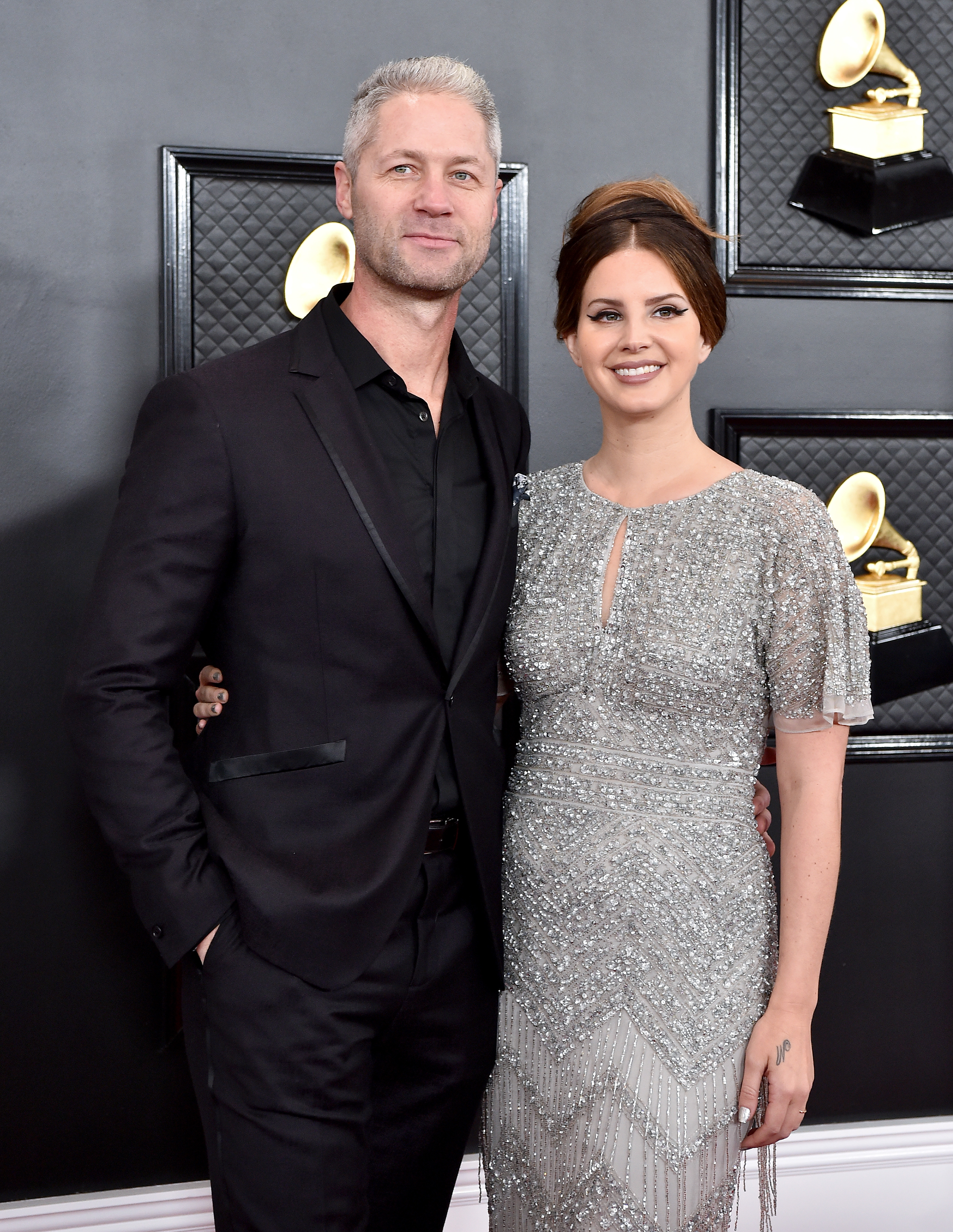 Eric Church and Joanna Cotten pose together; he in a black suit and she in a sparkling grey dress