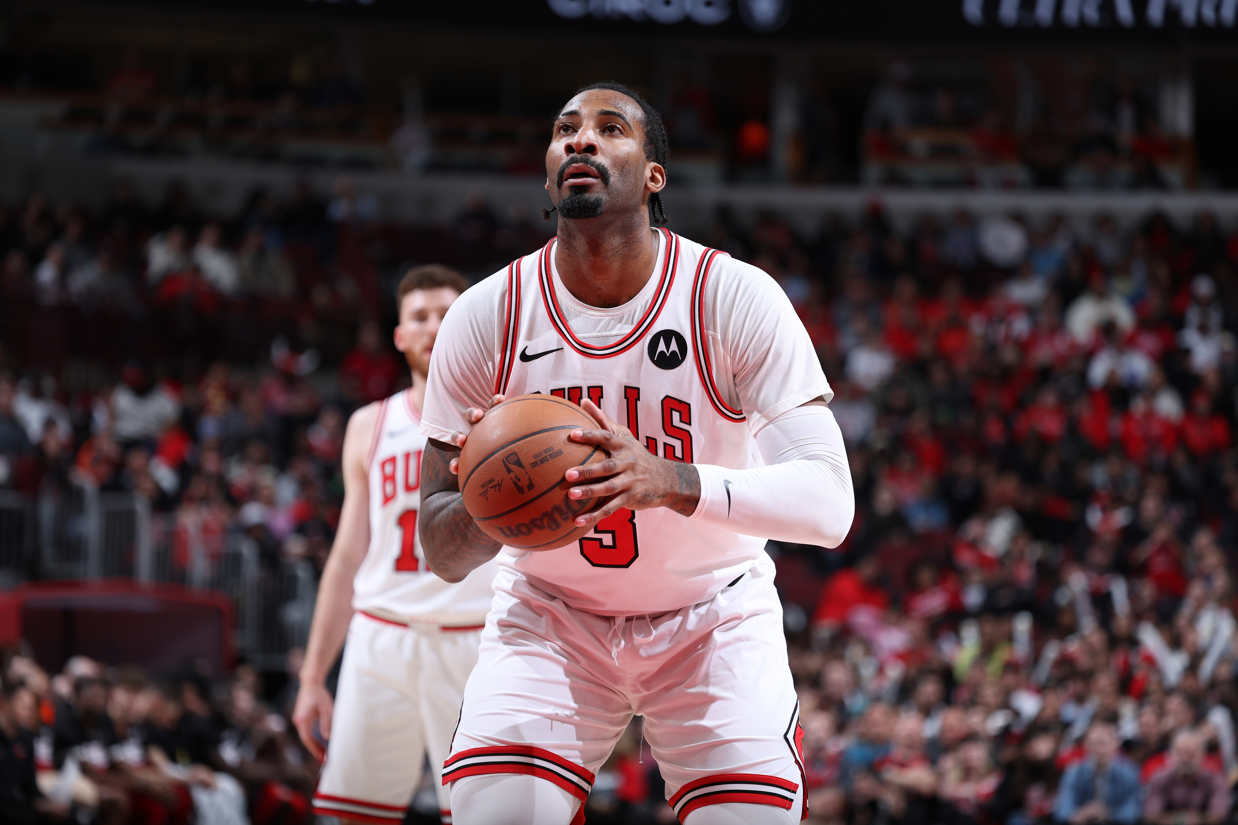 Chicago Bulls player in white uniform prepares to shoot a basketball during a game