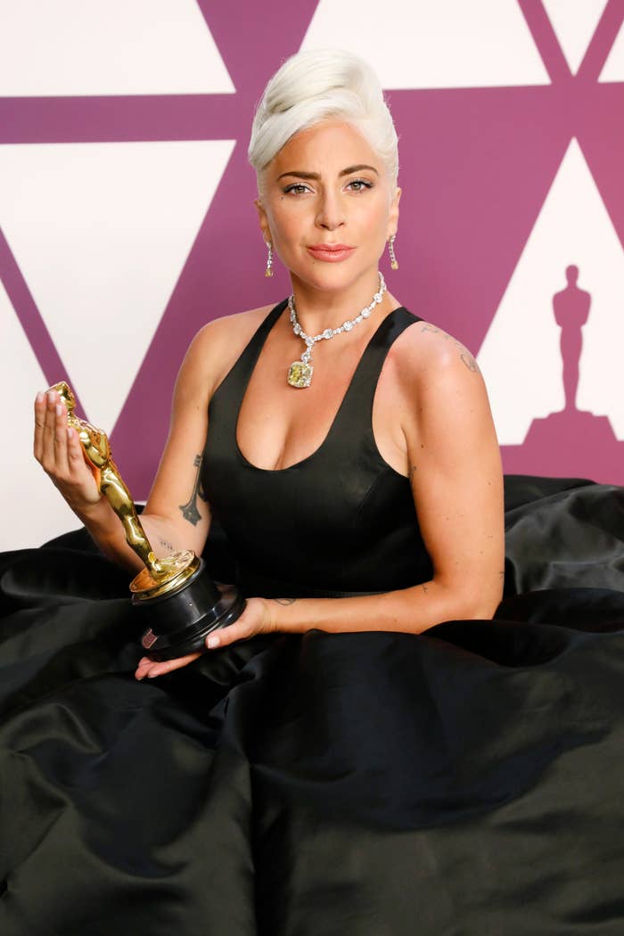 Lady Gaga in elegant attire holding an award at an event