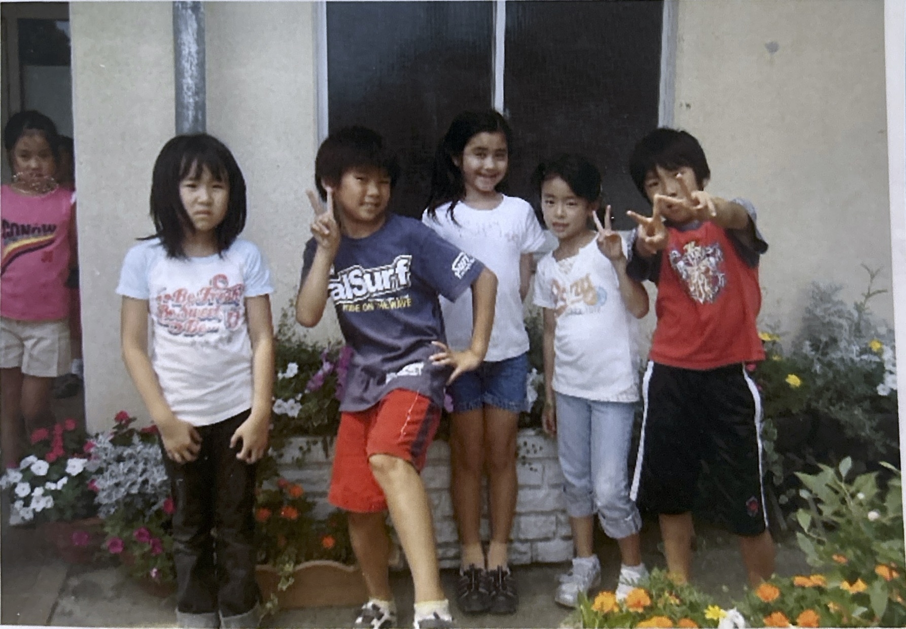 Group of children posing playfully in front of a building