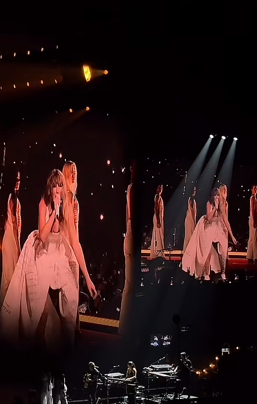 Taylor Swift performs on stage in a voluminous dress with backup singers in similar attire