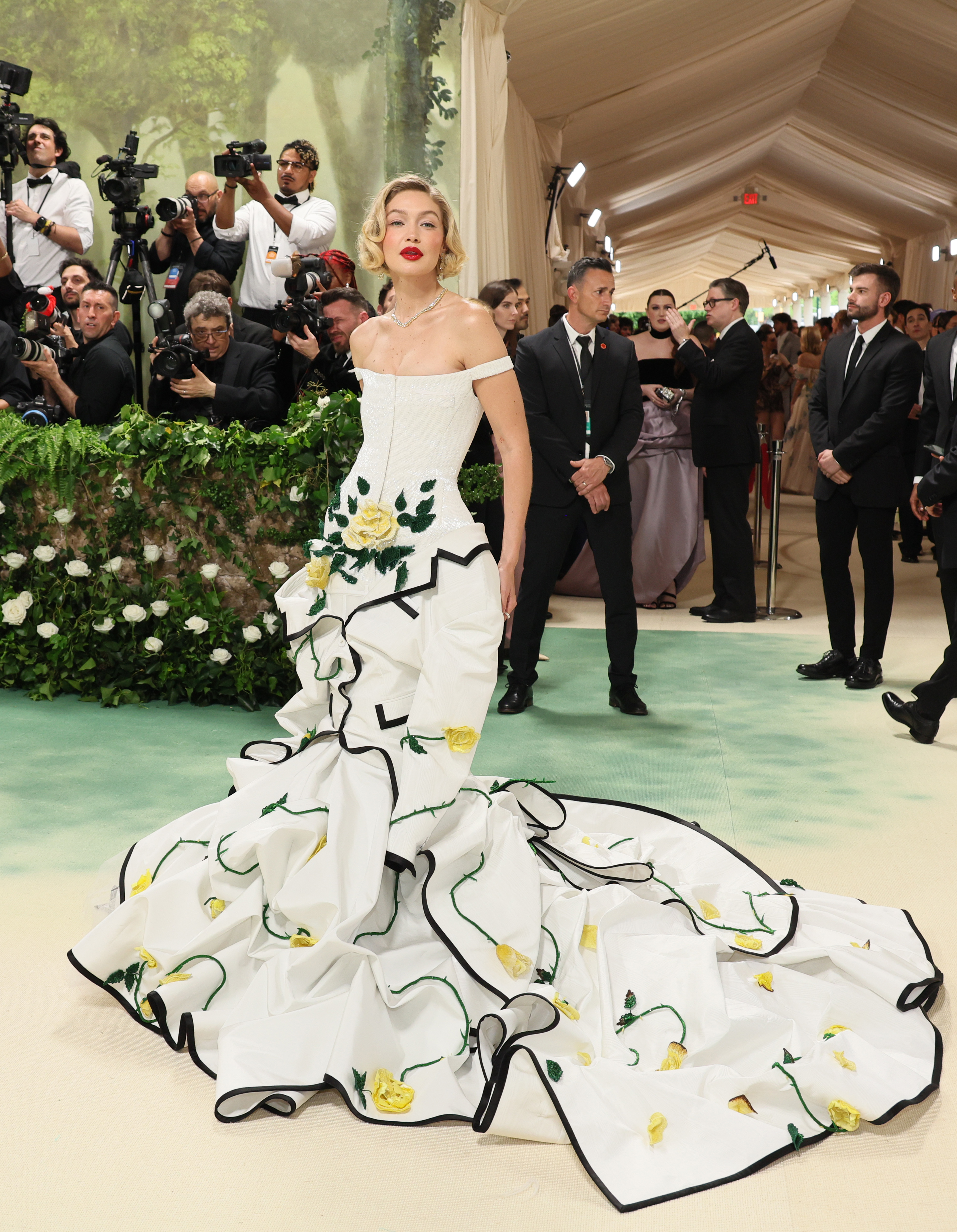 Gigi Hadid in a aff-the-shoulder gown with floral design on a voluminous train