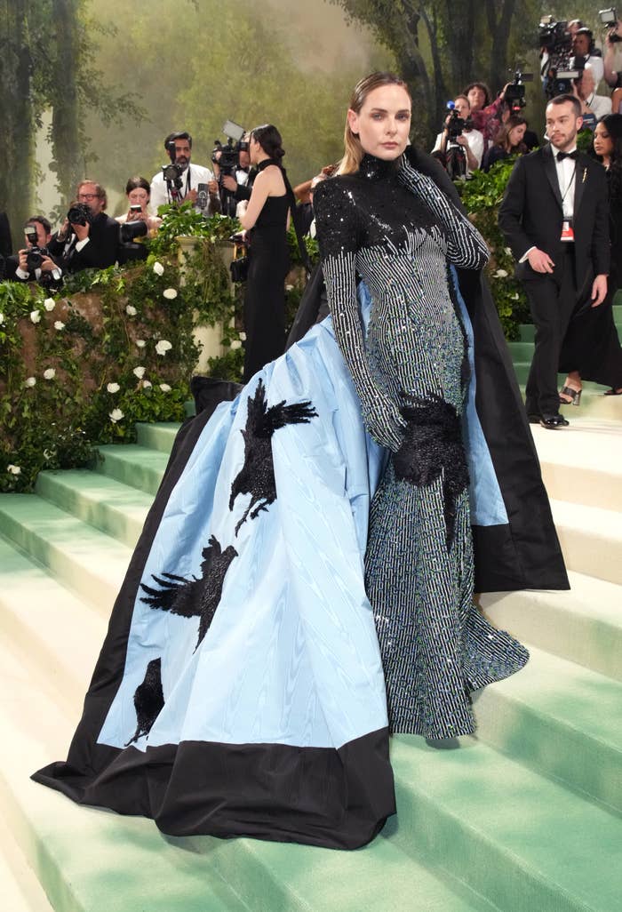 Rebecca Ferguson at the Met Gala in a dramatic gown featuring a bird motif that was revealed after removing her coat