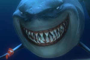 Animated shark smiling with pointy teeth, holding a spear, from the movie Finding Nemo