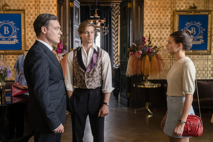 Personajes de ficción en una escena de hotel, hablando seriamente