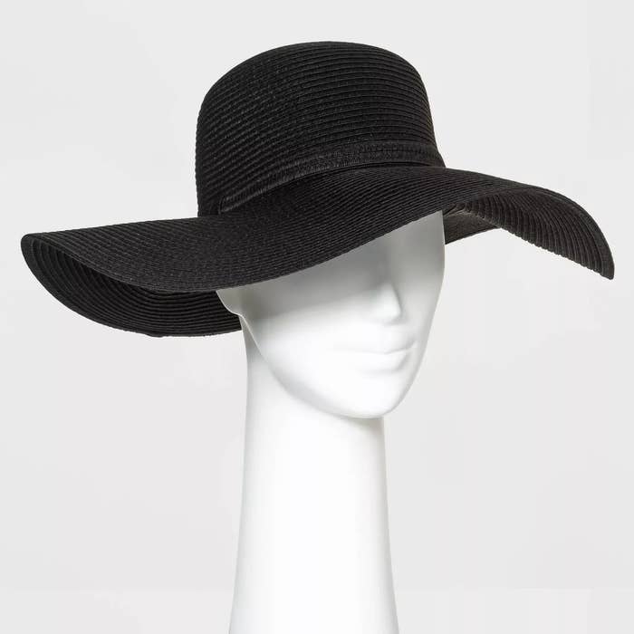 Mannequin head displaying a wide-brimmed black straw hat