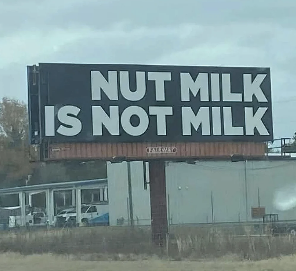 Billboard stating &quot;NUT MILK IS NOT MILK&quot; beside a road