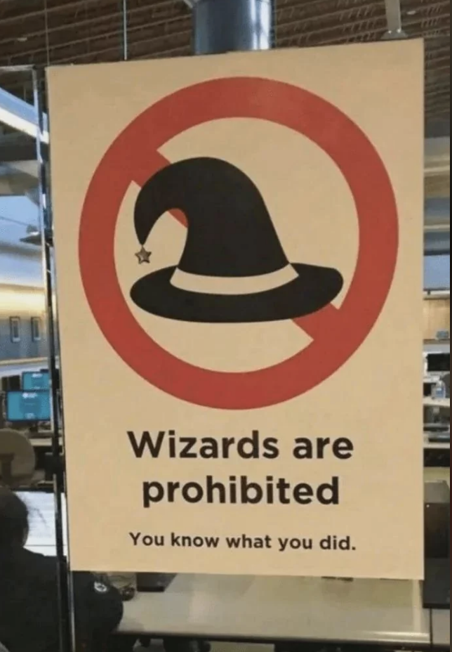 Sign with a wizard hat in a prohibitory circle, text reads &quot;Wizards are prohibited. You know what you did.&quot;