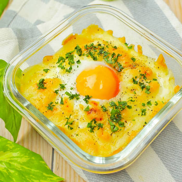 ガラス容器に入った卵とチーズの朝食料理、上にパセリが振りかけられている。