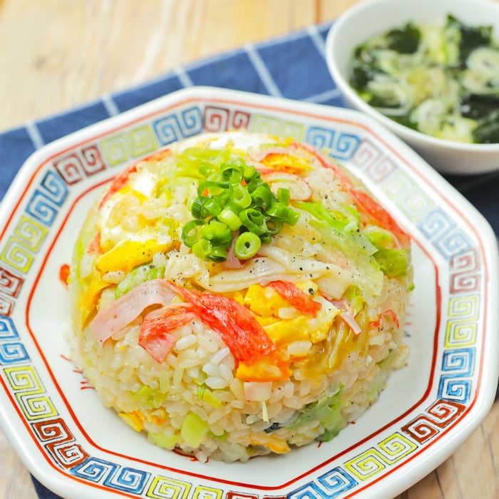 炒飯にネギがのっていて、横にスープが添えられています。