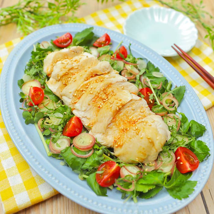 鶏肉と野菜のサラダ、盛り付けられた青い皿と箸が見える。