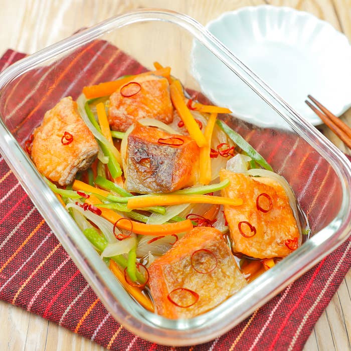 ガラス容器に入った野菜と魚の料理。