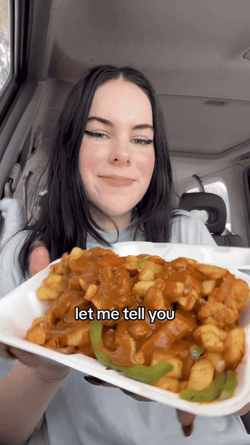 Person holds a plate of food, smiling at the camera with text overlay &quot;let me tell you&quot;