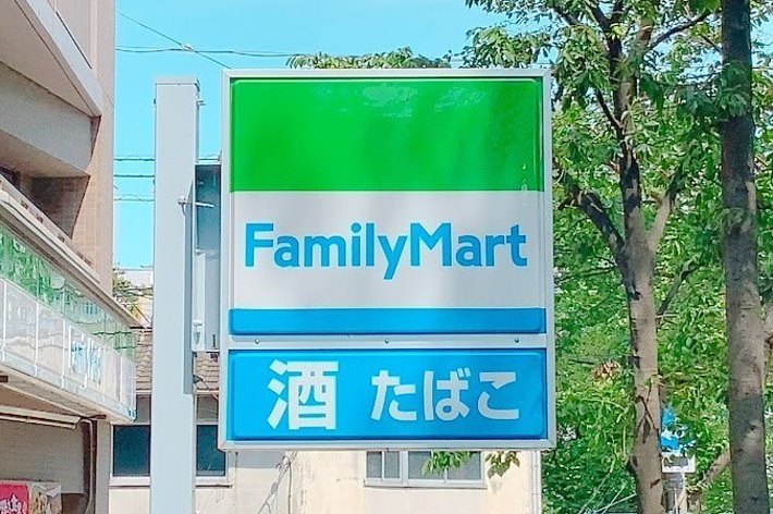 ファミリーマートの看板が街路樹の間にある。