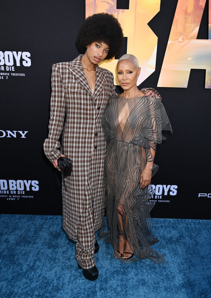 Willow Smith in a checkered suit and Jada Pinkett Smith in a sheer, fringed dress pose together at the "Bad Boys for Life" premiere event