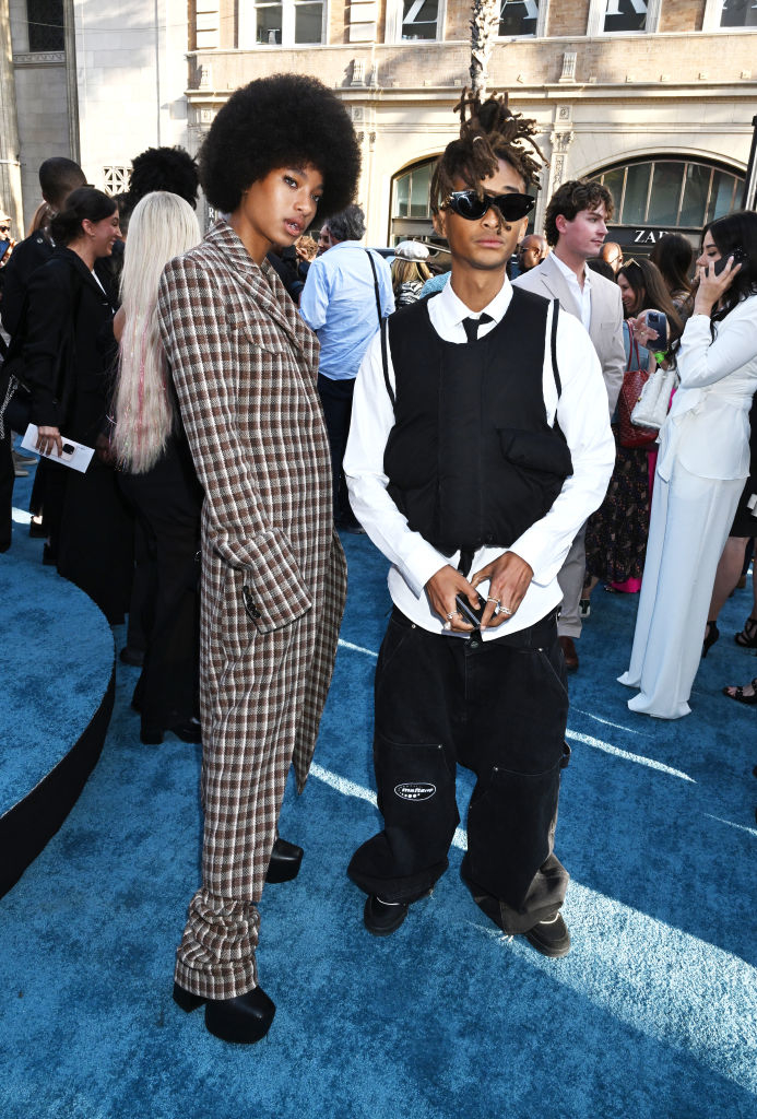 Willow Smith in a plaid suit and Jaden Smith in a layered white shirt and black vest with baggy pants at a public event