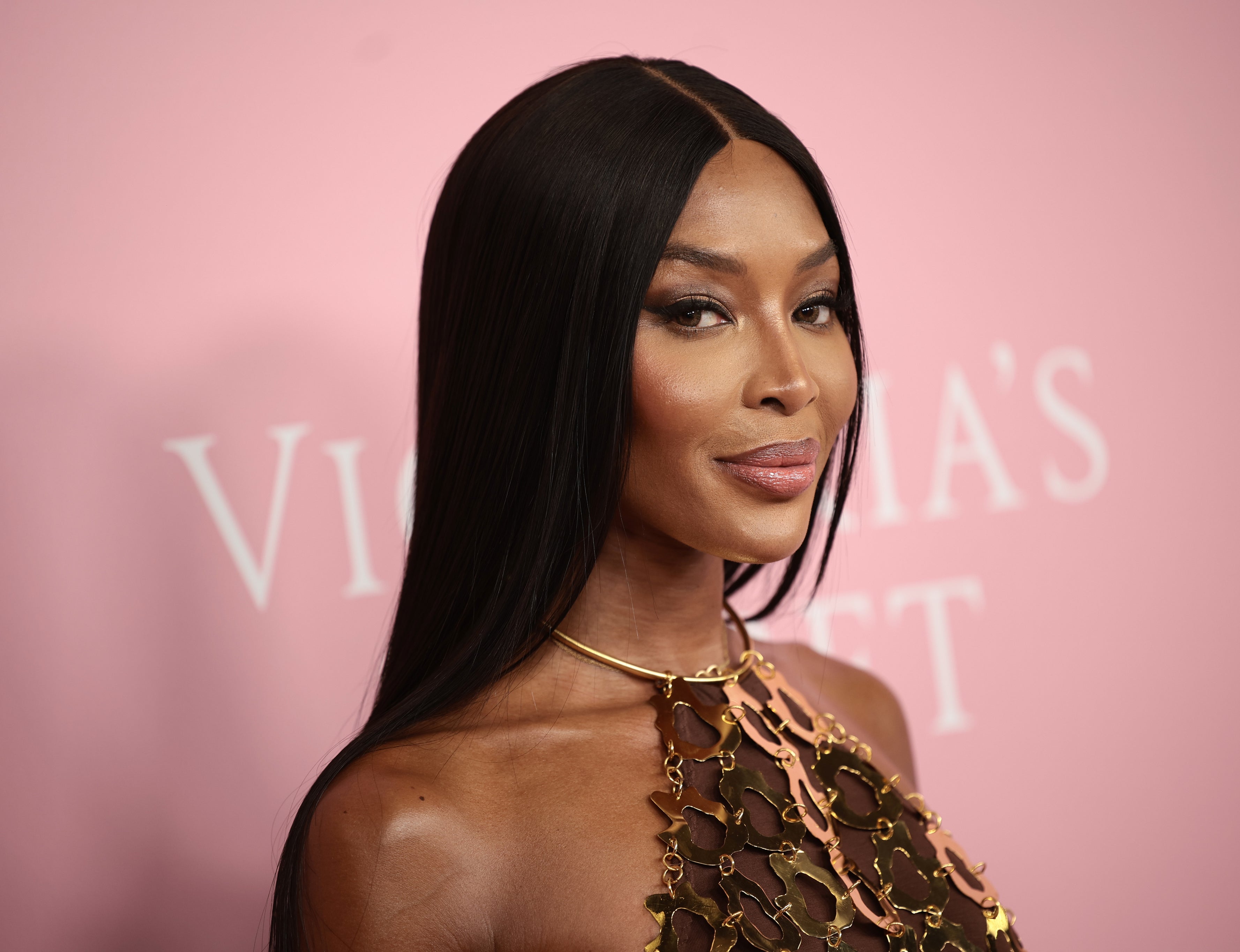 Naomi Campbell on the Victoria&#x27;s Secret red carpet, wearing a metallic, chain-like dress and a simple necklace