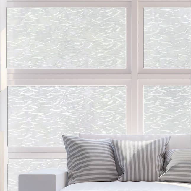 A modern living space in front of large, textured glass windows