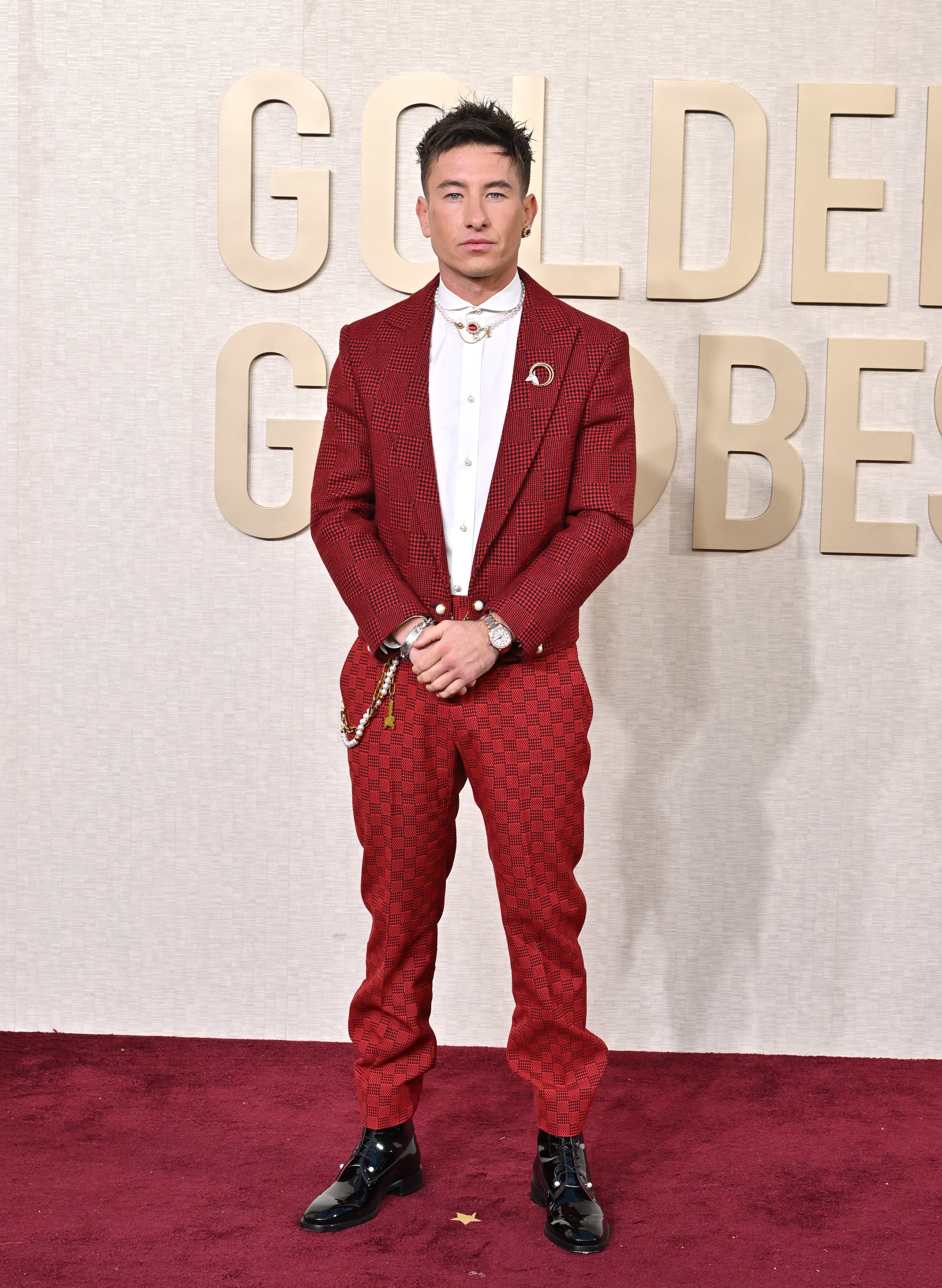 Barry Keoghan wearing a patterned suit and white shirt, standing on the red carpet at the Golden Globe Awards